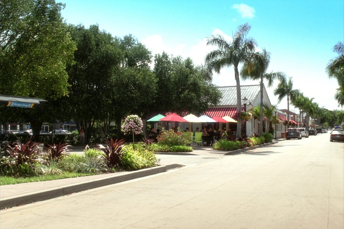 Palm-lined avenue with sidewalk cafes in Delray Beach, Florida