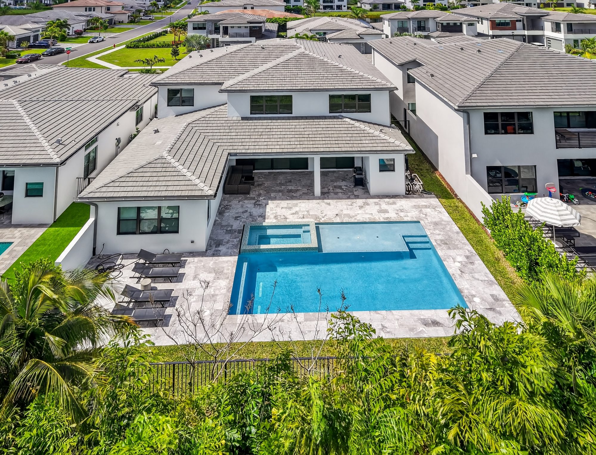Aerial view of a custom resort-style pool and covered outdoor living space at a GL Homes residence in Boca Raton