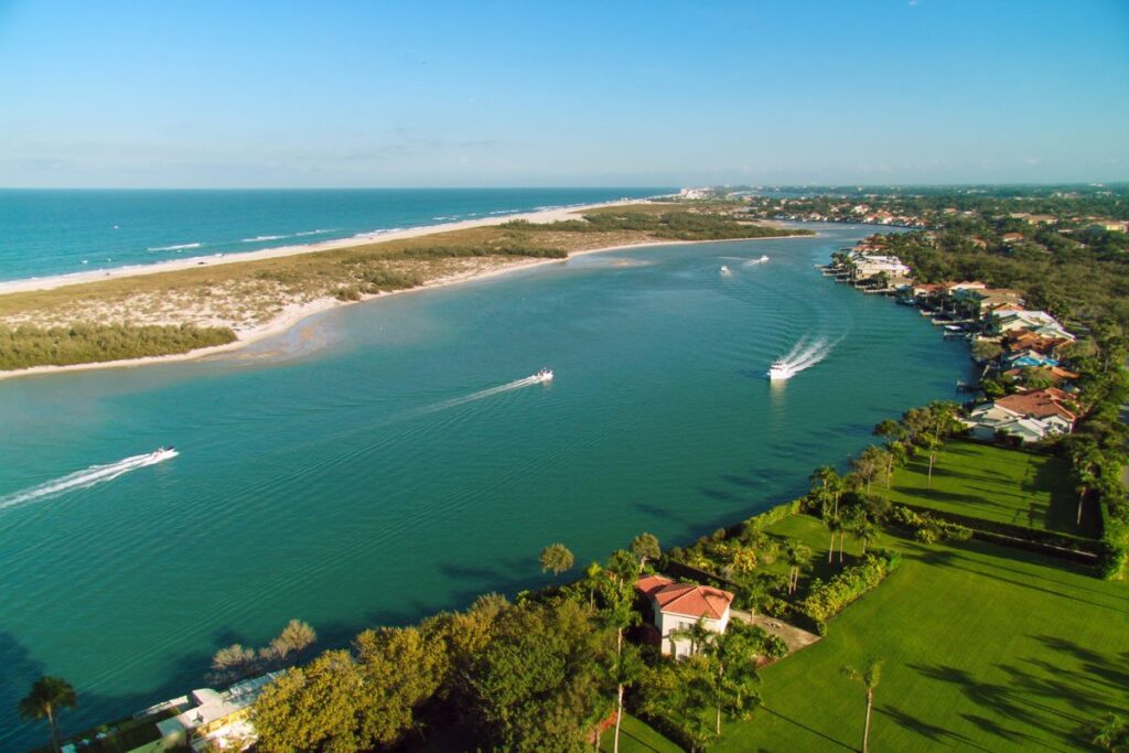 Boats cruising the inlet past waterfront homes in Jupiter, Florida